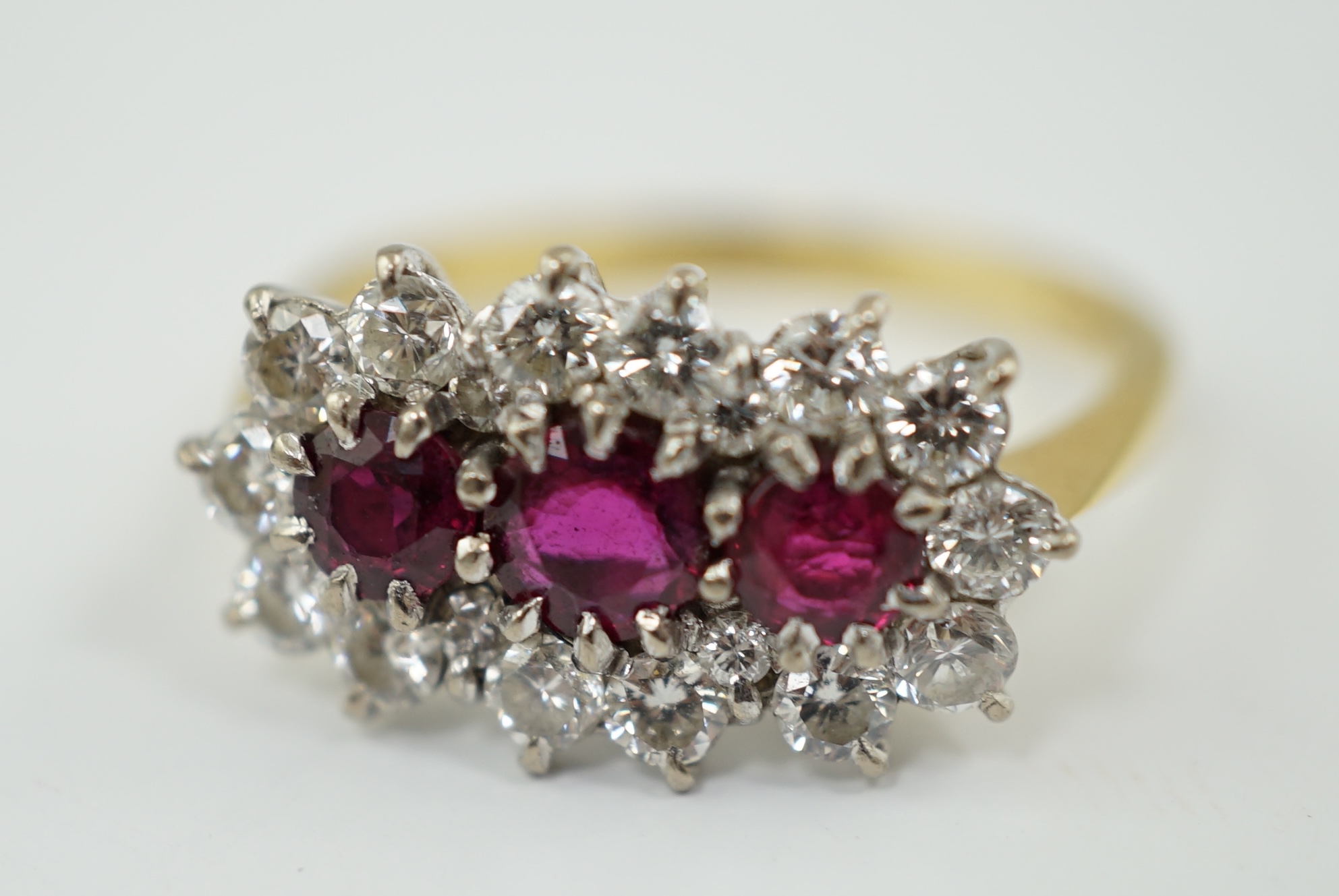 A modern 18ct gold, ruby and diamond set triple cluster ring